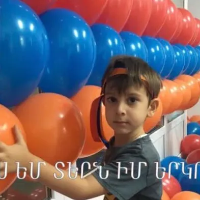 Տղան գնդակներով պատի մոտ