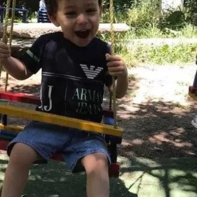 Տղան ճոճանակի վրա ծիծաղում է